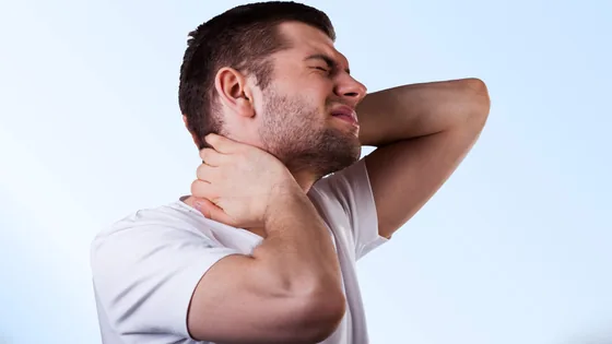 Homem com a mão na nuca, demonstrando dor na região cervical